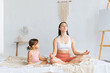 © Вадим Каштанов - Young sports family. Mom and her little daughter meditate in lotus position. Lesson with children. Couples yoga.