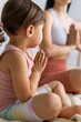 © Вадим Каштанов - Woman and little girl meditate in lotus position. Yoga class. Unrecognizable people.