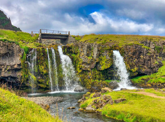 Sticker - Beautiful shot of a waterfall in a forest under the cloudy skies