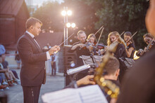Male Conductor Directing Orchestra Performance On The Street