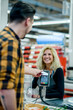 © Zamrznuti tonovi - Man making a contactless payment with his credit card at a supermarket