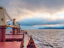 Dry Bulk Carrier Ship At Sea, Deck View To A Cloudy Sky