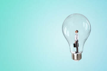 Wall Mural - Business man standing inside a light bulb