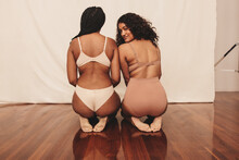 Two Confident Young Women Kneeling In Underwear