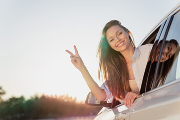 Sticker - Photo portrait smiling woman riding in car looking in window in shirt showing v-sign gesture