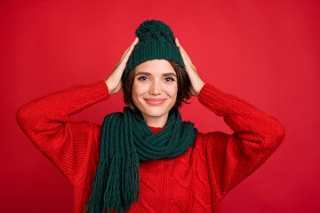 Wall Mural - Photo portrait young woman wearing knitted headwear scarf isolated vibrant red color background