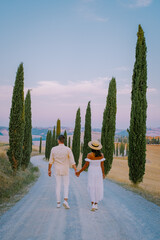 Wall Mural - Tuscany Italy, Perfect Road Avenue through cypress trees ideal Tuscan landscape Italy, couple man and woman on vacation in Toscane