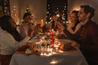 © Syda Productions - holidays and celebration concept - multiethnic group of happy friends with sparklers having christmas dinner at home