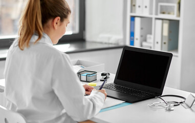 Sticker - healthcare, technology and medicine concept - female doctor in white coat with laptop computer working at hospital