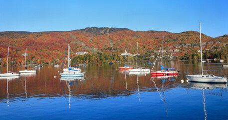 Wall Mural - Panoramic view of Mont Tremblant and lake in autumn with colorful yachts on the foreground, Quebec, Canada