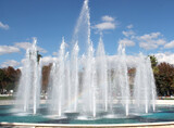 Fototapeta Tęcza - fountain in the park against the blue sky