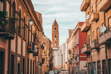 Fototapeta Uliczki - Old street with a tower in Italy