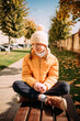 © Анна Молько - girl in a yellow jacket and hat on a background of autumn trees. autumn in the city. joyful time of year.
