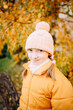 © Анна Молько - girl in a yellow jacket and hat on a background of autumn trees. autumn in the city. joyful time of year.