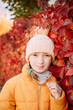 © Анна Молько - girl in a yellow jacket and hat on a background of autumn trees. autumn in the city. joyful time of year.