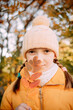 © Анна Молько - girl in a yellow jacket and hat on a background of autumn trees. autumn in the city. joyful time of year.