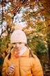 © Анна Молько - girl in a yellow jacket and hat on a background of autumn trees. autumn in the city. joyful time of year.