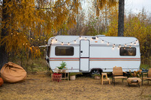 House On Wheels. Cozy Wicker Furniture By The Van Against The Backdrop Of An Autumn Forest.