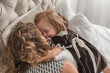 © Alison Winterroth/Stocksy - Girl snuggles with mother