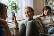 © Pietro Karras/Stocksy - Man showing smartphone screen to friends