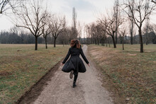Woman Running Alone In A Park. Isolation From Society To Feel Again Part Of Nature.