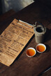 © Pietro Karras/Stocksy - Ancient teapot with aromatic tea in bowls at table with vintage paper menu