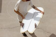 © Nicole Mason/Stocksy - person holding surfboard on concrete