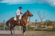 Argentine cowboy (gaucho) walks his horse past camera, in Patagonia.
