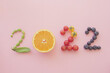 2022 made from healthy food and fruit on pastel pink background, New year health resolution, diet goal plan and lifestyle wellness concept