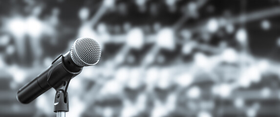 Microphone Public speaking background, Close-up the microphone on stand for speaker speech presentation stage performance with blur and bokeh light background.