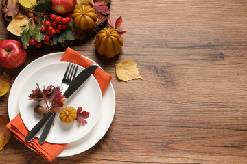 Canvas Print - Festive table setting with autumn decor on wooden background, flat lay. Space for text