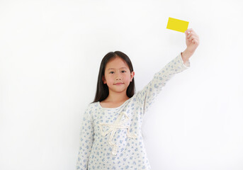 Wall Mural - Asian little girl child holding yellow card over white background