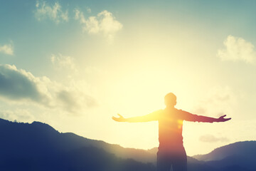 Copy space of man rise hand up on top of mountain and sunset sky abstract background.