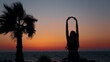 Silhouette of slender young woman doing fitness exercises on beach during amazigh summer sunset over ocean. Concept of freedom, active and healthy lifestyles.