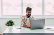© F8  \ Suport Ukraine - Indian man working at office and talking on mobile