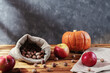 Pumpkin, red apples and hazelnuts in autumn vintage still life.