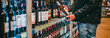 © pavel siamionov - man hand holding bottle wine in grocery store in supermarket