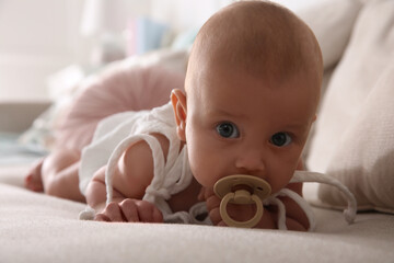 Canvas Print - Cute little baby with pacifier on sofa at home