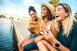 © Davide Angelini - Three young female friends sitting outdoor and eating pizza - Happy women having fun enjoying a day out on city street - Happy lifestyle concept