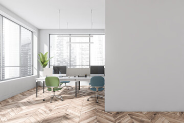 Empty white wall and open space with blue and green office chairs