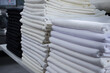 © Romi - Stack of folded black and white cloths in an industrial laundry.
