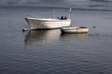 Two Small White Boats Parked On The River. Recreational Fishing Boat