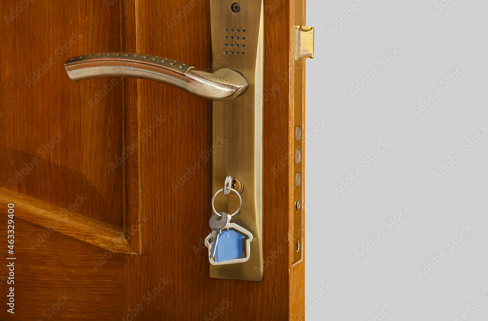 Key with house shaped keychain in door lock, closeup