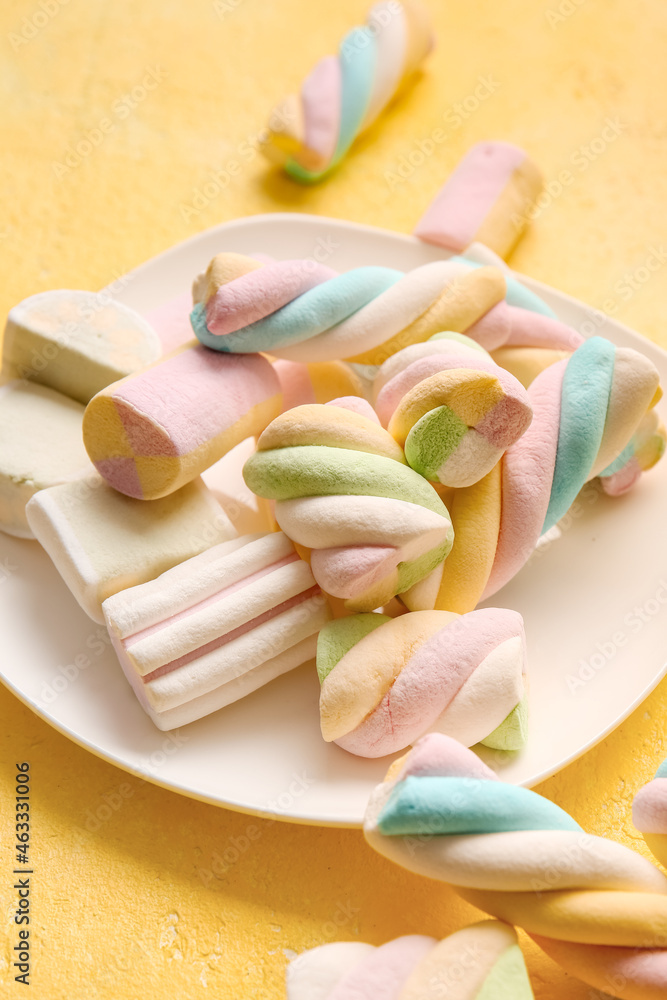 Plate with sweet marshmallows on color background, closeup