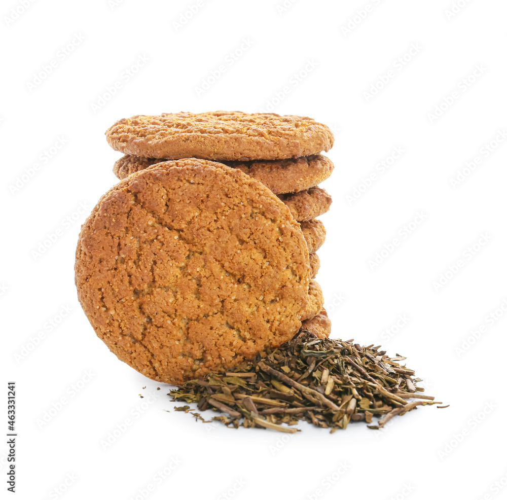 Tasty hojicha cookies and dry leaves on white background