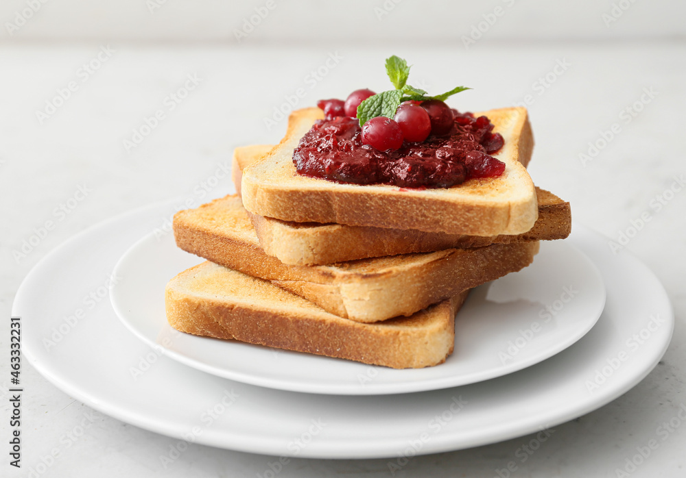 Plate with toasts and cranberry jam on light background, closeup