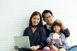 © amorn - Portrait of young Asian family sitting together at home. Young Asian father, mother and their cute little daughter sitting together and looking at camera with happy and smile at home in holiday