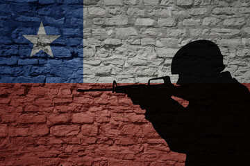 Wall Mural - Soldier silhouette on the old brick wall with flag of chile country.