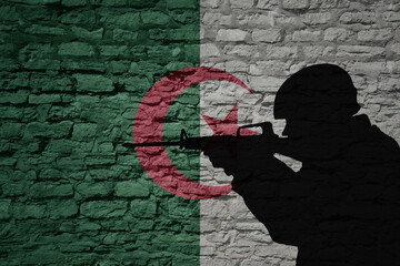Wall Mural - Soldier silhouette on the old brick wall with flag of algeria country.