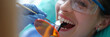 Doctor dentist treating teeth using LED curing light machine in clinic closeup